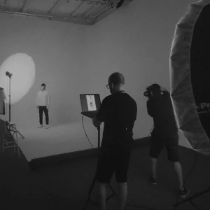 Asistente de plató ayudando en una sesión fotográfica con iluminación de estudio
